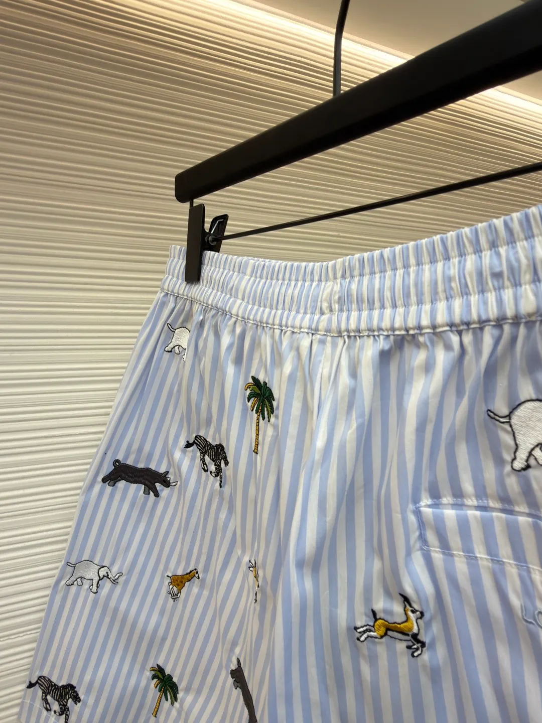 LOUIS VUITTON Animal and plant nostalgic style embroidered striped shorts ●Original version: purchased and developed by 14616 ●Item number: 1682542-A75 ●Fabric: cotton fabric ●Technology: embroidery production ●Color: blue ●Version: fitted version ●Weight: about 205 grams ●Size: S-M-L-XL ●Description: Made of high-count pure cotton poplin fabric. After pre-washing process, it feels smooth and breathable. It has both drape and stiffness, and is not easy to wrinkle and deform. The blue and white vertical stripes on the body are woven with yarn-dyed technology, and the texture is clear and does not fade. The animal and coconut tree patterns are presented with sophisticated embroidery technology. The embroidery threads are full of color and the stitches are dense. The patterns are three-dimensional and vivid, forming a rich visual hierarchy with the stripe base. The shirt has a Cuban collar style, with smooth necklines, custom mother-of-pearl buttons at the placket, and a warm texture. The overall shape is loose, the shoulder joints are straight and fine, the cuffs are cuffed with exquisite craftsmanship, custom accessories and three logos are complete, and the details are full of luxury craftsmanship. It is suitable for casual vacations and daily outings, etc. The overall wiring is straight and delicate, the fabric is comfortable and soft, and the color is consistent without color difference. It can be matched with the same style to create a fashionable look and control various occasions. Customized accessories, complete with three standards, same style for men and women!